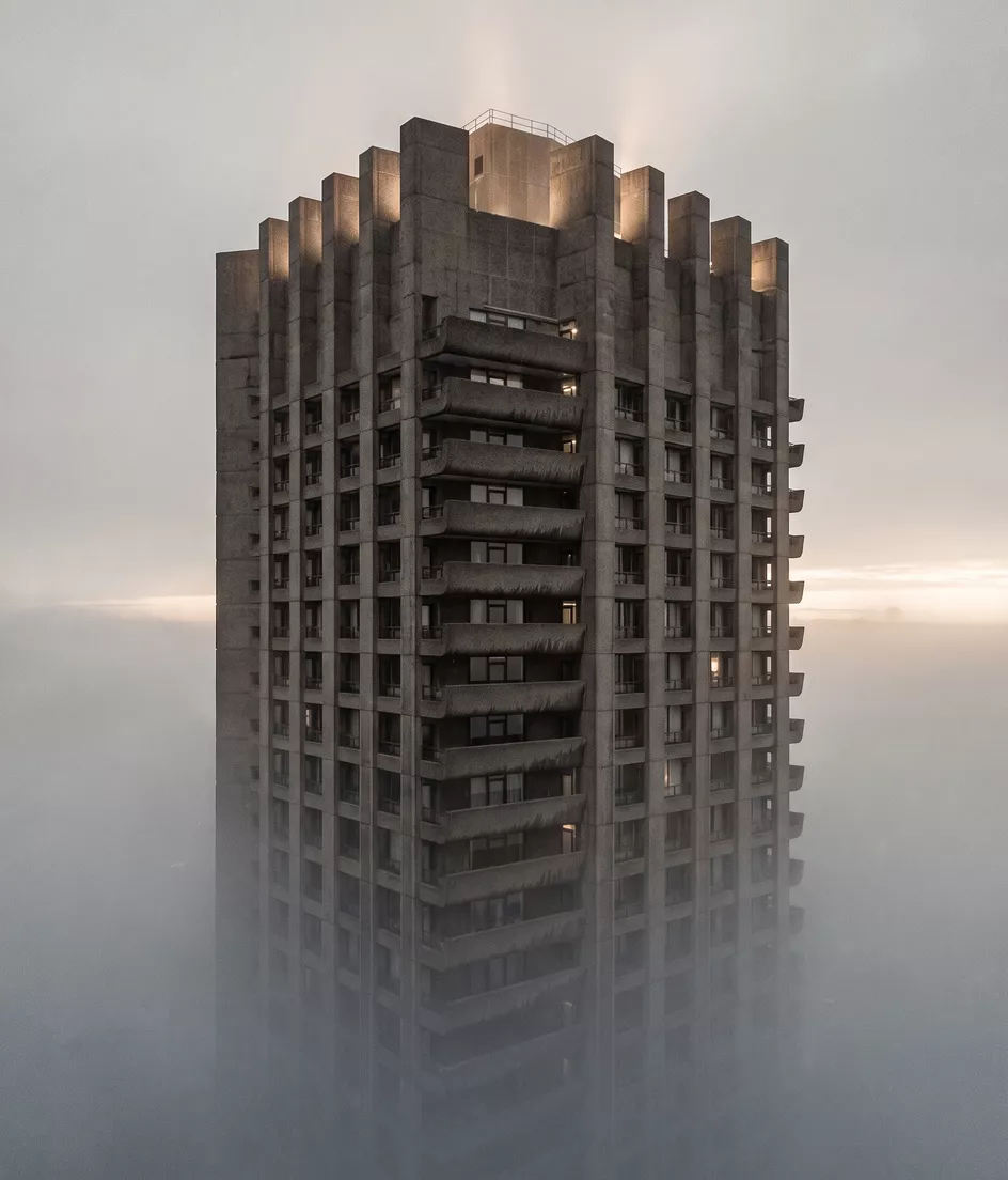 A brutalist skyscraper rising out of morning fog